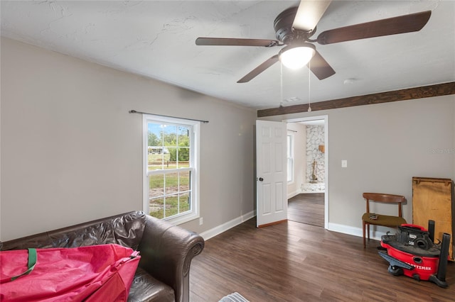 living area with ceiling fan and dark wood-type flooring