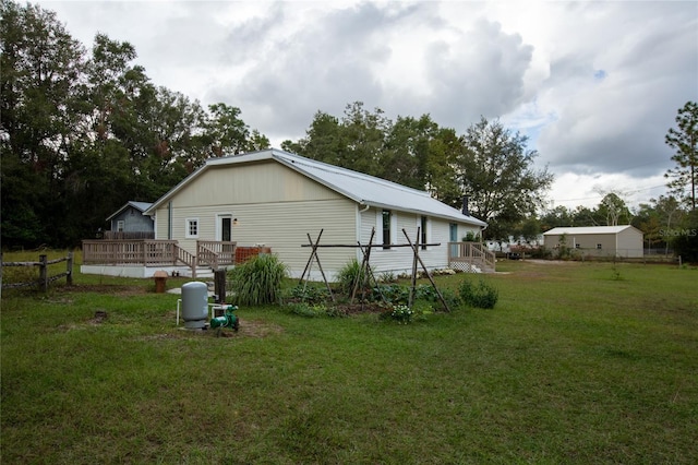 view of side of home with a wooden deck and a yard