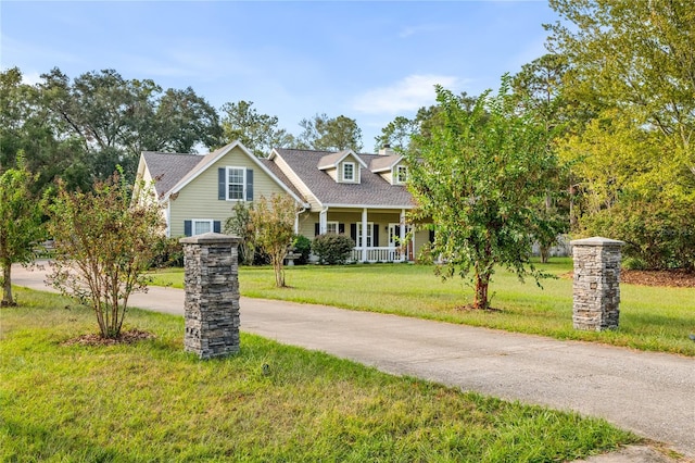 cape cod house featuring driveway, a front yard, and covered porch