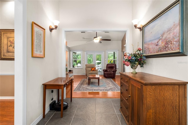 hallway with dark tile patterned flooring and vaulted ceiling