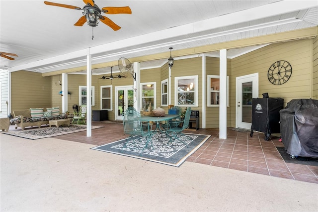 sunroom featuring a ceiling fan, outdoor lounge area, and beam ceiling