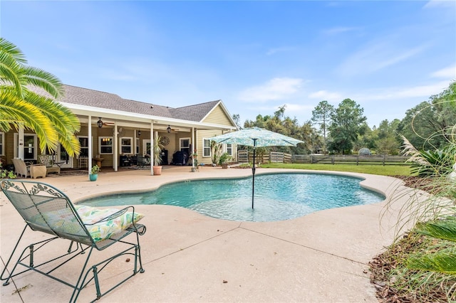 outdoor pool with a ceiling fan, a patio area, and fence