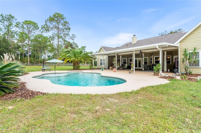 view of swimming pool featuring a lawn, ceiling fan, and a patio