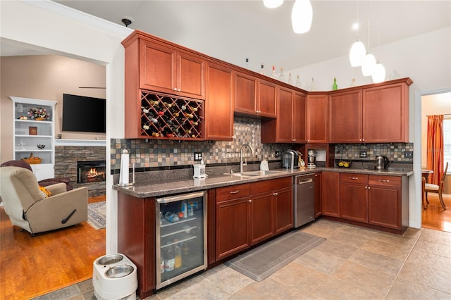 kitchen with sink, tasteful backsplash, a stone fireplace, beverage cooler, and dishwasher