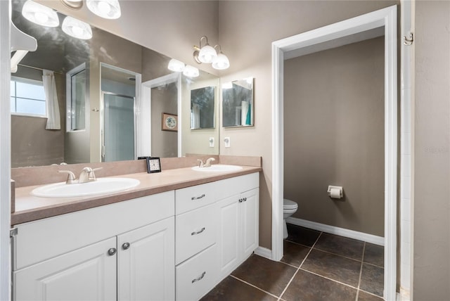 bathroom with toilet, vanity, tile patterned flooring, and walk in shower