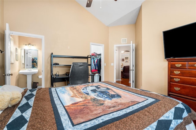 bedroom featuring ensuite bathroom, high vaulted ceiling, ceiling fan, a closet, and a walk in closet