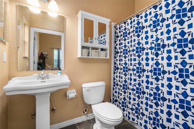 bathroom with a shower with shower curtain, tile patterned floors, toilet, and sink