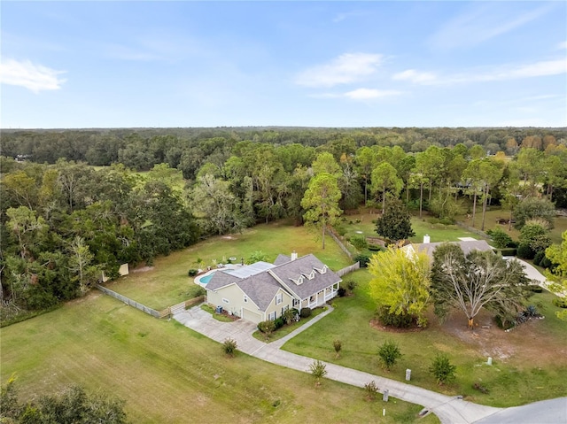 aerial view of property and surrounding area featuring a forest