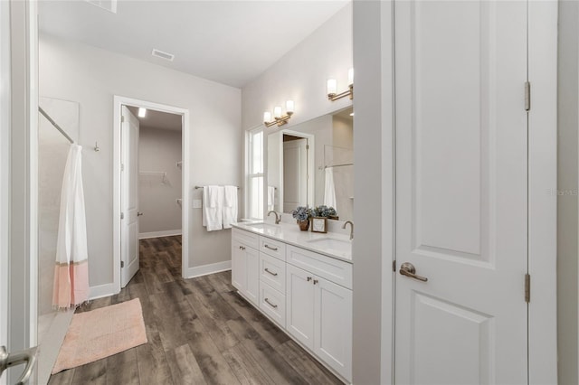 1035 NW 132nd Blvd, Newberry, FL 32669 - full bathroom with double vanity, wood finished floors, a shower with shower curtain, baseboards, and a spacious closet