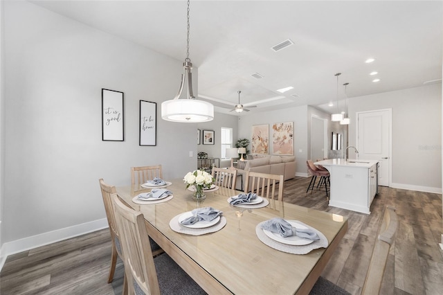 dining space with dark wood-type flooring, ceiling fan, and sink