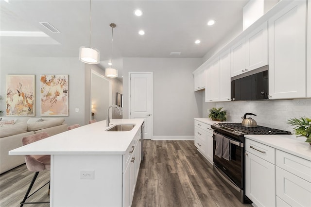 1035 NW 132nd Blvd, Newberry, FL 32669 - kitchen featuring stainless steel microwave, range with gas stovetop, a sink, backsplash, and dark wood-style flooring