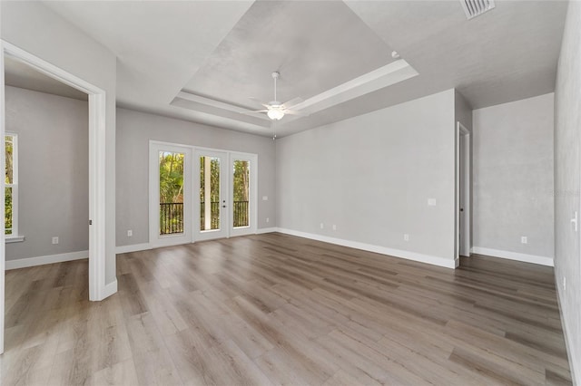 1029 NW 132nd Blvd, Newberry, FL 32669 - empty room with a ceiling fan, a tray ceiling, baseboards, and wood finished floors