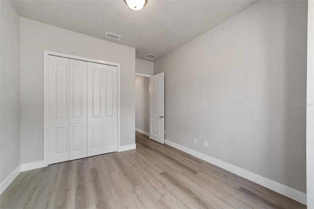 unfurnished bedroom with a closet and light wood-type flooring