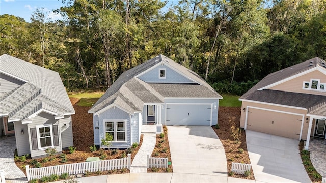 1029 NW 132nd Blvd, Newberry, FL 32669 - view of front of home with concrete driveway, roof with shingles, an attached garage, fence, and view of wooded area