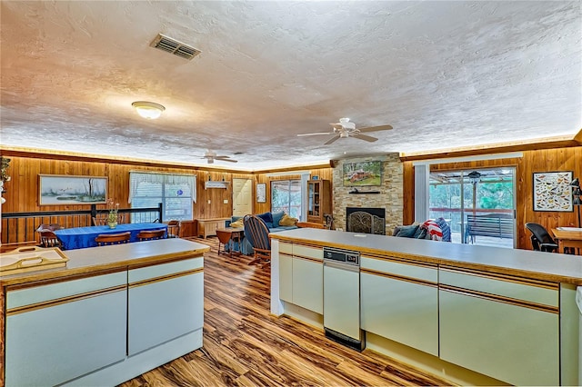 kitchen with visible vents, a healthy amount of sunlight, wood finished floors, and wood walls