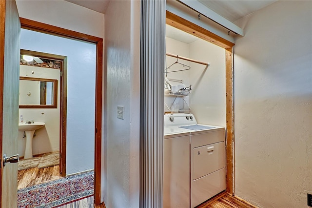 laundry area featuring independent washer and dryer, laundry area, and light wood-type flooring