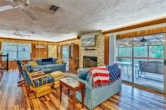 living room with visible vents, a textured ceiling, a healthy amount of sunlight, and wood finished floors