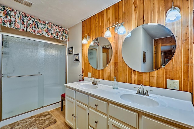 full bath featuring a sink, visible vents, a stall shower, and wood walls