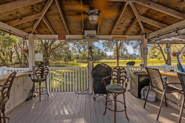 wooden deck with a gazebo, a rural view, an outdoor bar, and grilling area