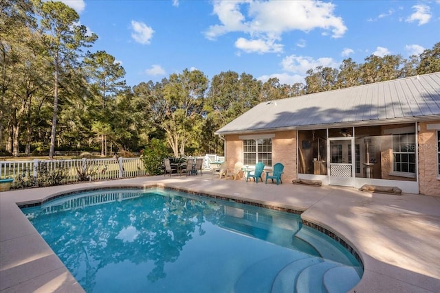 view of pool with a sunroom and a patio