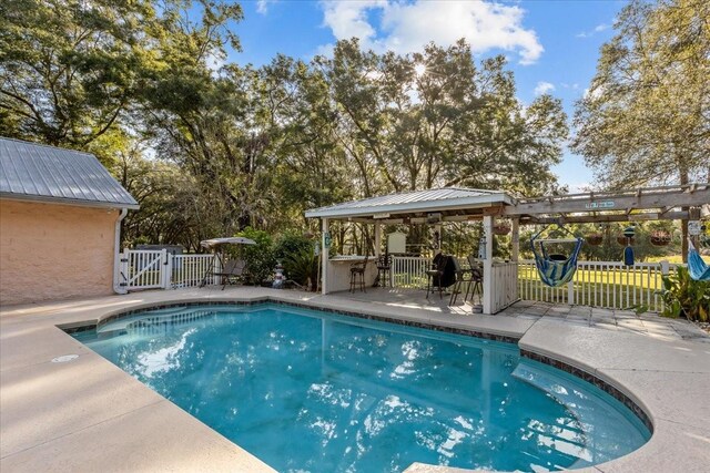 view of pool with a gazebo, a bar, and a patio