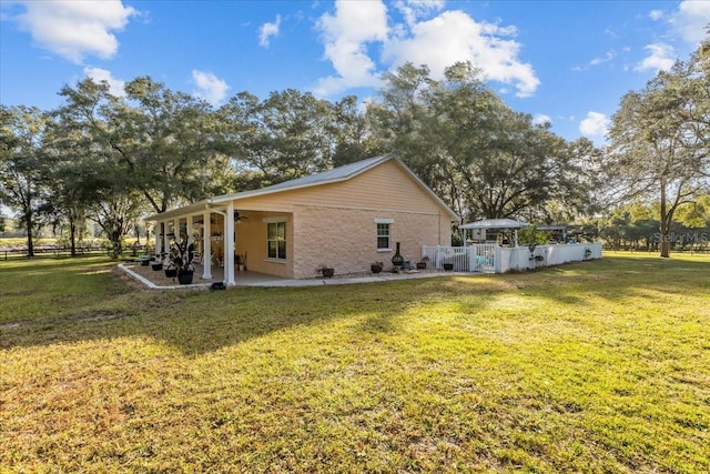 back of property featuring a patio, ceiling fan, and a lawn