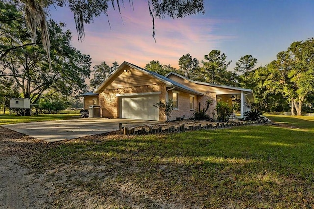 ranch-style house with a garage and a lawn