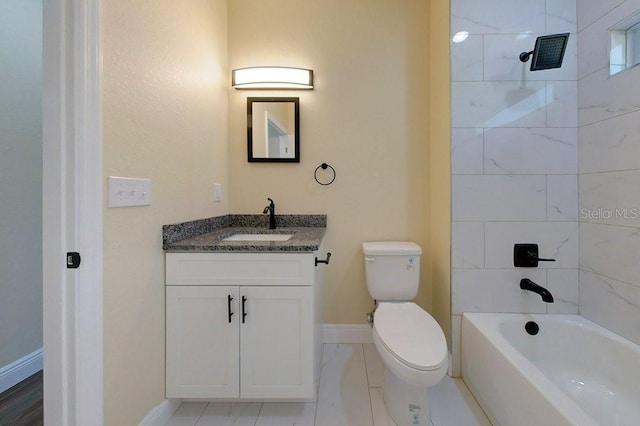 full bathroom featuring tiled shower / bath, vanity, and toilet