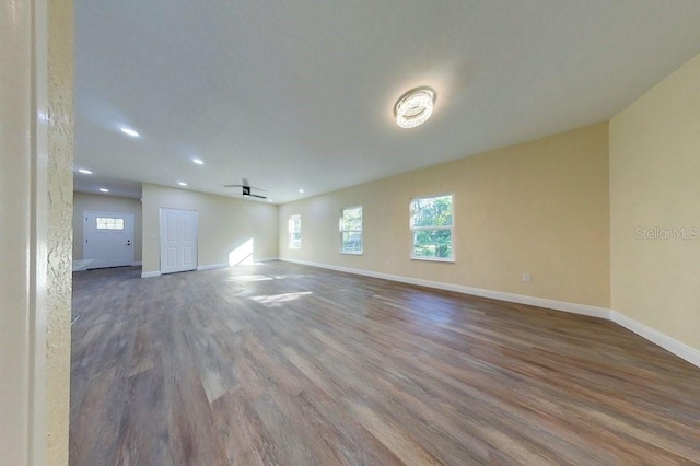 unfurnished living room with wood-type flooring and ceiling fan