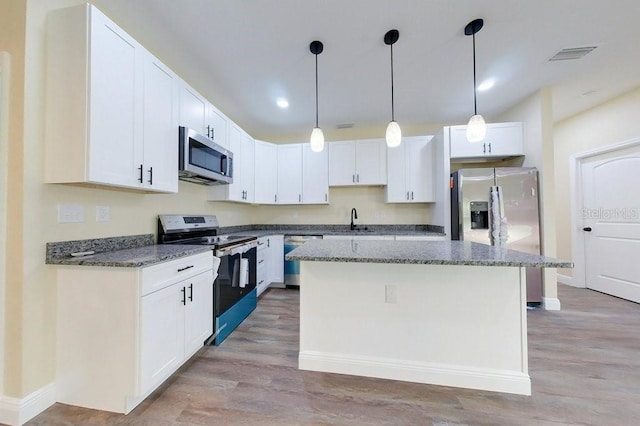 kitchen featuring white cabinets, a kitchen island, light hardwood / wood-style floors, and appliances with stainless steel finishes