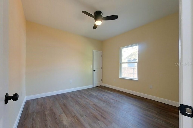 spare room with ceiling fan and dark wood-type flooring