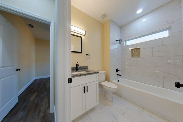 full bathroom featuring hardwood / wood-style floors, vanity, toilet, and tiled shower / bath combo