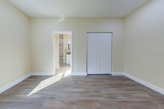 unfurnished bedroom with hardwood / wood-style floors and a closet