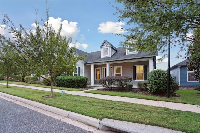 cape cod home featuring a porch and a front lawn