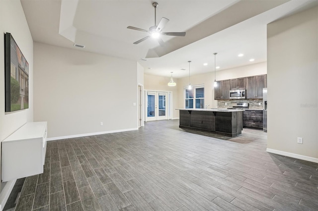 unfurnished living room featuring dark wood-type flooring, ceiling fan, and french doors