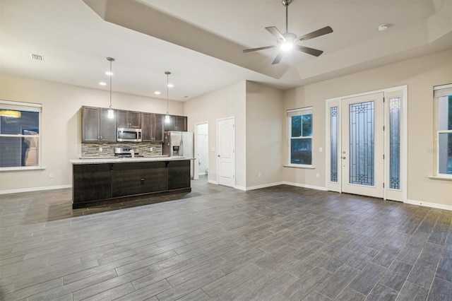 unfurnished living room with dark wood-type flooring and ceiling fan