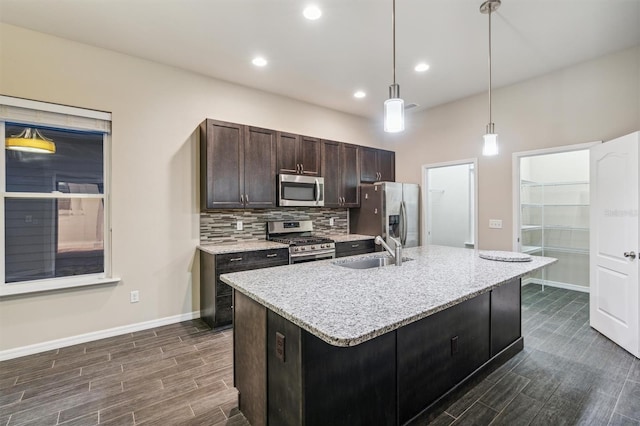 kitchen with an island with sink, dark hardwood / wood-style floors, sink, and appliances with stainless steel finishes