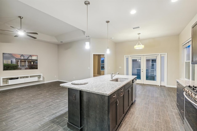 kitchen with french doors, stainless steel appliances, a center island with sink, sink, and dark hardwood / wood-style floors