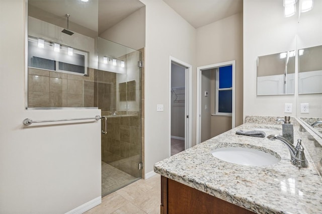 bathroom with walk in shower, vanity, and tile patterned flooring