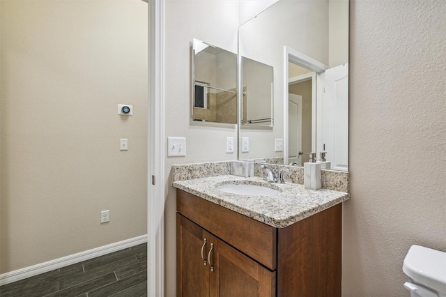 bathroom featuring hardwood / wood-style floors, vanity, and toilet