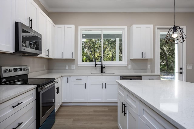 kitchen featuring white cabinetry, sink, light stone counters, appliances with stainless steel finishes, and light wood-type flooring