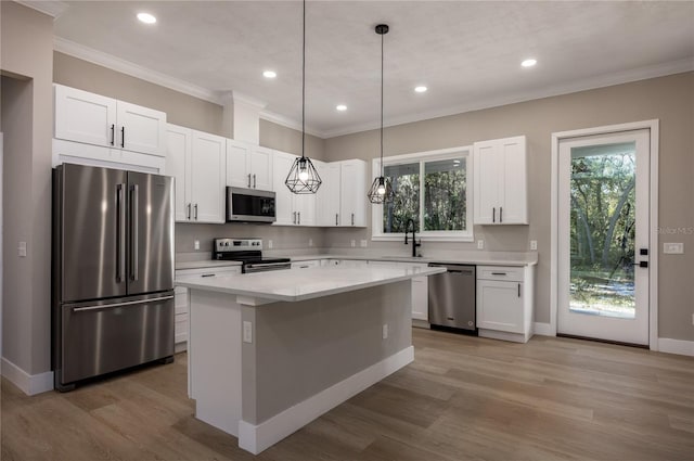 kitchen featuring white cabinets, plenty of natural light, a center island, and appliances with stainless steel finishes