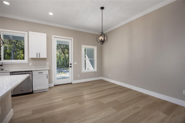 unfurnished dining area with a chandelier, light hardwood / wood-style floors, plenty of natural light, and ornamental molding