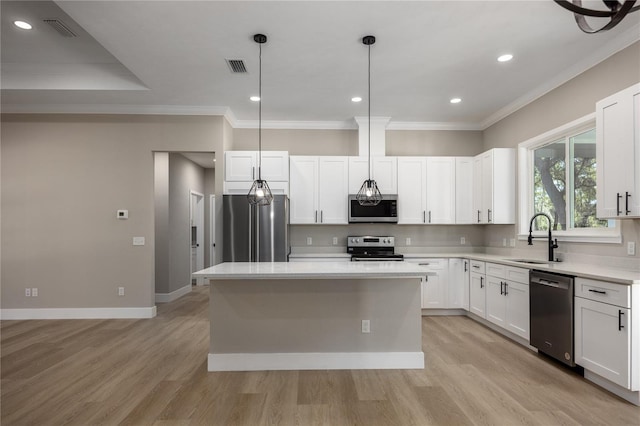 kitchen featuring a center island, hanging light fixtures, sink, light wood-type flooring, and appliances with stainless steel finishes