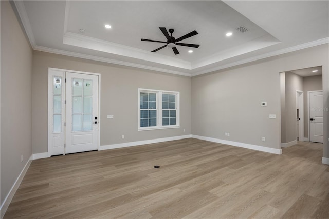 interior space with ceiling fan, light hardwood / wood-style floors, crown molding, and a tray ceiling