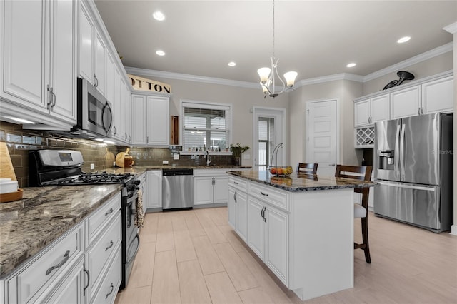 1237 NW 137th Way, Newberry, FL 32669 - kitchen featuring stainless steel appliances, white cabinets, a breakfast bar, crown molding, and recessed lighting