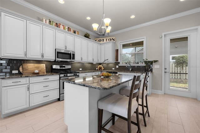 1237 NW 137th Way, Newberry, FL 32669 - kitchen featuring appliances with stainless steel finishes, a chandelier, tasteful backsplash, white cabinetry, and a breakfast bar area