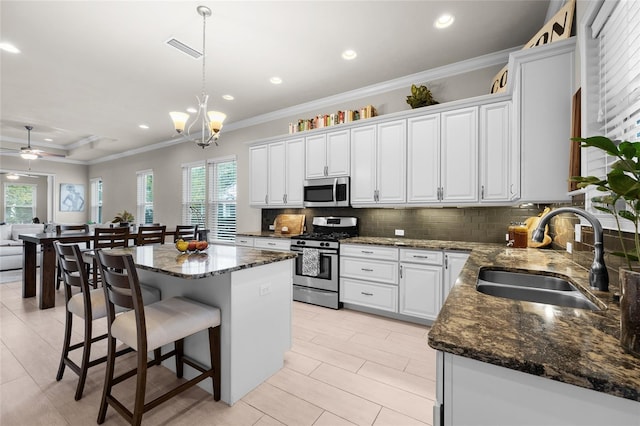 1237 NW 137th Way, Newberry, FL 32669 - kitchen featuring appliances with stainless steel finishes, a sink, decorative backsplash, crown molding, and a kitchen island