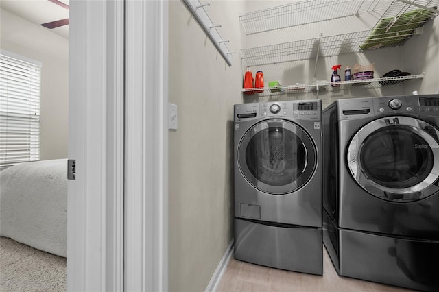 laundry room featuring separate washer and dryer, light hardwood / wood-style flooring, and ceiling fan