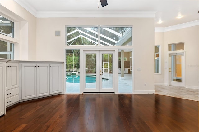 entryway with french doors, dark wood-type flooring, ceiling fan, and crown molding